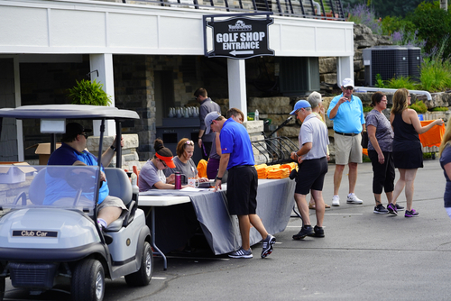 Men signing up for Golf Outing at a table in front of the Golf Shop